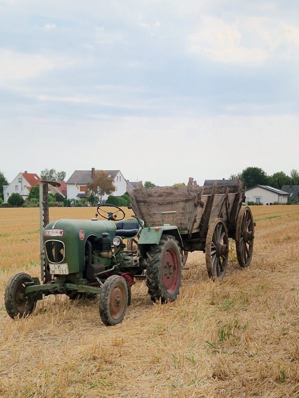 Passend zum Anlass: Oldtimer mit historischem Ackerwagen am Gelände.